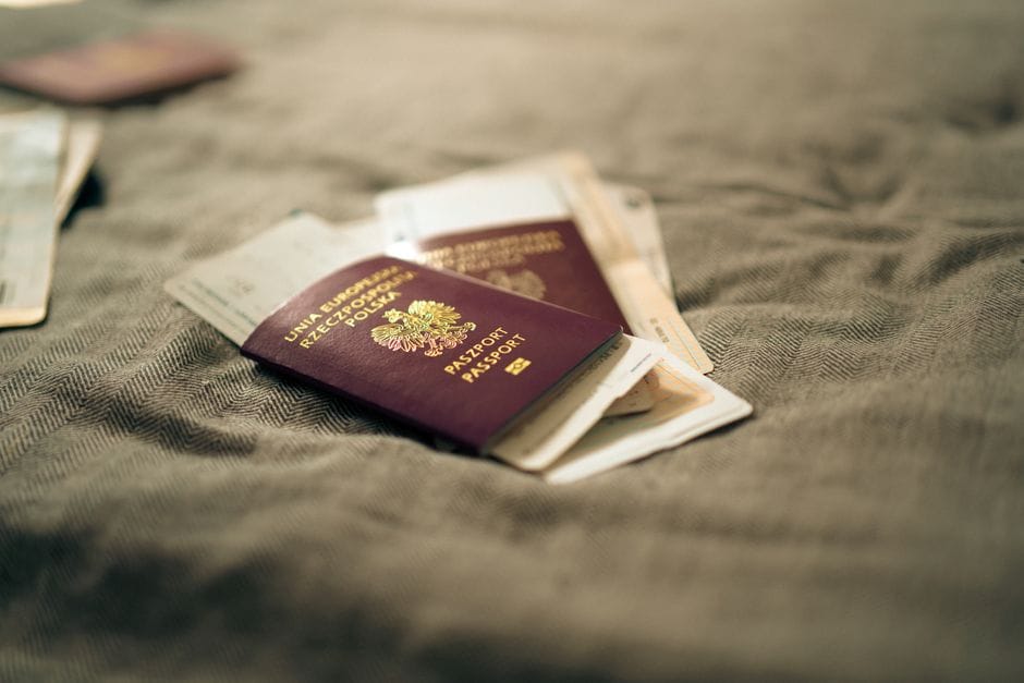 Person holding immigration documents and passport at an application desk