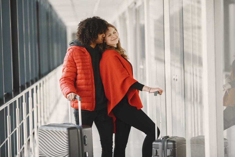 African travelers with luggage waiting at an international airport
